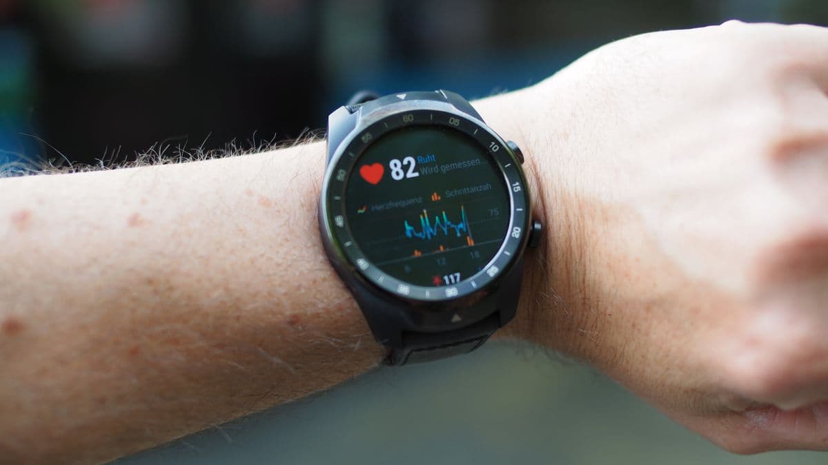 A smartwatch on a wrist showing a heart rate reading