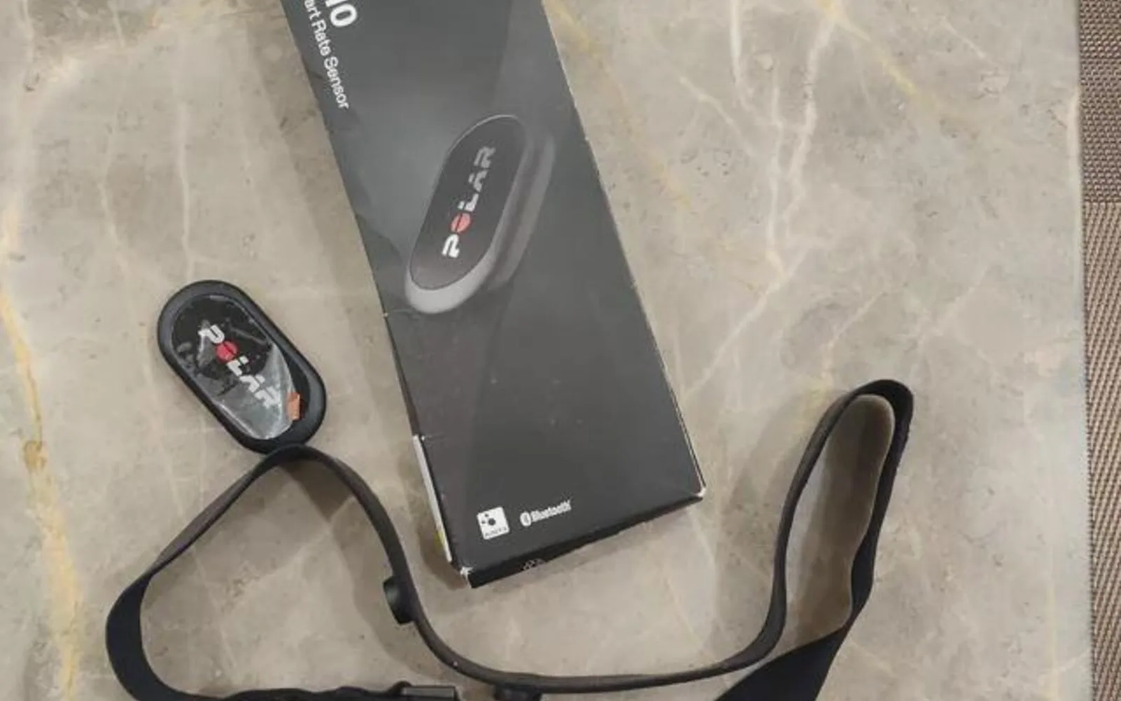 Polar H10 heart rate sensor, chest strap and box on a countertop
